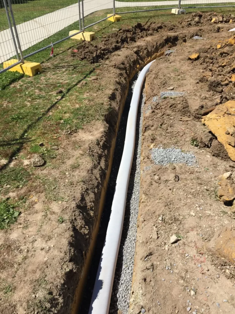 open trench for french drain showing pipe and gravel